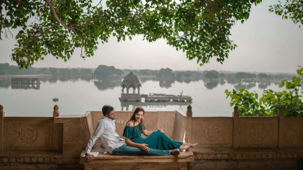 A couple enjoys a peaceful moment on a stone bench with a scenic lakeside view.