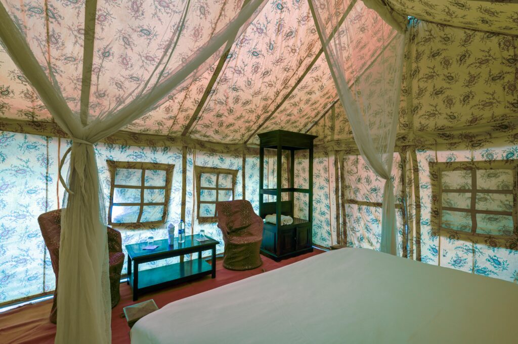 Cozy glamping tent interior in Jaisalmer, Rajasthan, featuring comfortable furniture and elegant decor.